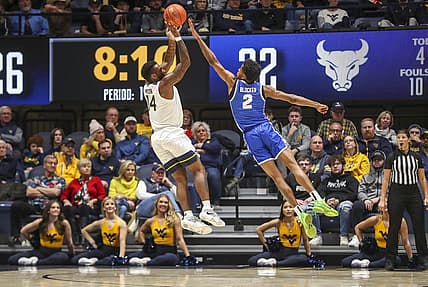 Dec 18, 2022; Morgantown, West Virginia, USA; West Virginia Mountaineers guard Seth Wilson (14) shoots over Buffalo Bulls guard Kidtrell Blocker (2) during the first half at WVU Coliseum. Mandatory Credit: Ben Queen-USA TODAY Sports