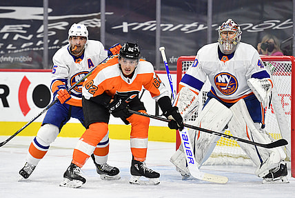 Jan 30, 2021; Philadelphia, Pennsylvania, USA; New York Islanders right wing Cal Clutterbuck (15) checks Philadelphia Flyers center Connor Bunnaman (82) in front of goaltender Semyon Varlamov (40) during the second period at Wells Fargo Center. Mandatory Credit: Eric Hartline-USA TODAY Sports