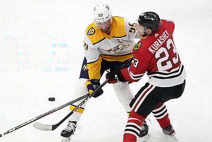 Apr 21, 2021; Chicago, Illinois, USA; Nashville Predators defenseman Roman Josi (59) checks Chicago Blackhawks left wing Philipp Kurashev (23) during the first period at the United Center. Mandatory Credit: Mike Dinovo-USA TODAY Sports