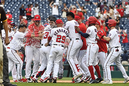 Jul 18, 2021; Washington, District of Columbia, USA; Washington Nationals shortstop Alcides Escobar (3) is mobbed by teammates after hitting a walk off RBI single against the San Diego Padres during the ninth inning at Nationals Park. Mandatory Credit: Brad Mills-USA TODAY Sports