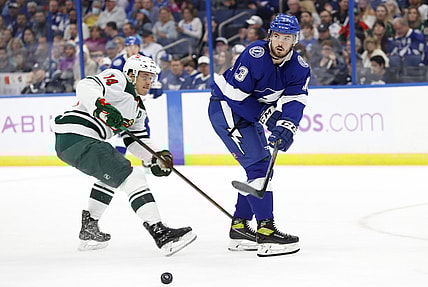 Nov 21, 2021; Tampa, Florida, USA; Tampa Bay Lightning defenseman Fredrik Claesson (3) passes the puck as Minnesota Wild center Joel Eriksson Ek (14) defends during the first period at Amalie Arena. Mandatory Credit: Kim Klement-USA TODAY Sports