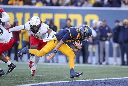 Nov 18, 2023; Morgantown, West Virginia, USA; West Virginia Mountaineers quarterback Garrett Greene (6) runs the ball for a touchdown during the first quarter against the Cincinnati Bearcats at Mountaineer Field at Milan Puskar Stadium. Mandatory Credit: Ben Queen-USA TODAY Sports