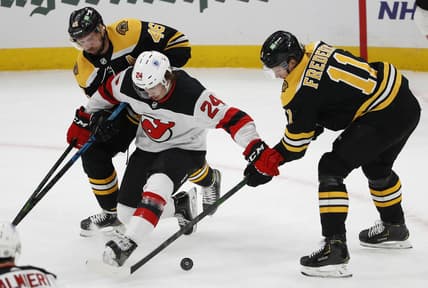 Mar 7, 2021; Boston, Massachusetts, USA; New Jersey Devils defenseman Ty Smith (24) tries to hold off Boston Bruins center Trent Frederic (11) and center David Krejci (46) during the first period at TD Garden. Mandatory Credit: Winslow Townson-USA TODAY Sports