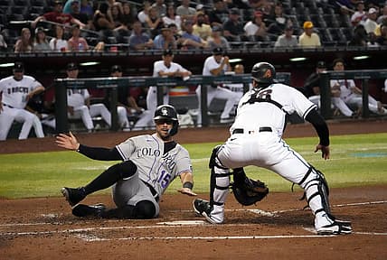 Jul 7, 2022; Phoenix, Arizona, USA; Colorado Rockies right fielder Randal Grichuk (15) beats the tag of Arizona Diamondbacks catcher Carson Kelly (18) to score a run during the fourth inning at Chase Field. Mandatory Credit: Joe Camporeale-USA TODAY Sports
