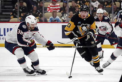 Mar 5, 2024; Pittsburgh, Pennsylvania, USA; Pittsburgh Penguins left wing Drew O'Connor (10) moves the puck up ice against Columbus Blue Jackets center Boone Jenner (38) during the first period at PPG Paints Arena. Mandatory Credit: Charles LeClaire-USA TODAY Sports