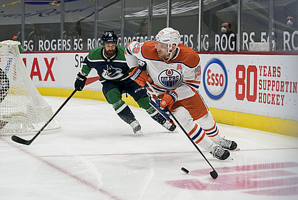 Feb 23, 2021; Vancouver, British Columbia, CAN; Vancouver Canucks defenseman Jordie Benn (8) defends Edmonton Oilers forward Leon Draisaitl (29) in the first period at Rogers Arena. Mandatory Credit: Bob Frid-USA TODAY Sports