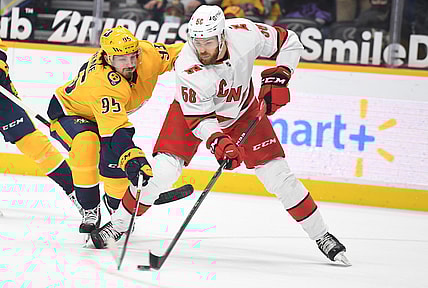 May 8, 2021; Nashville, Tennessee, USA; Carolina Hurricanes defenseman Jani Hakanpaa (58) looks to pass the puck as he is pressured by Nashville Predators center Matt Duchene (95) during the first period at Bridgestone Arena. Mandatory Credit: Christopher Hanewinckel-USA TODAY Sports
