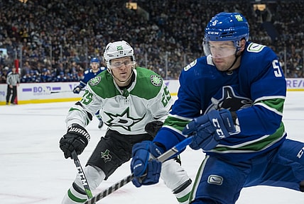 Nov 7, 2021; Vancouver, British Columbia, CAN;Dallas Stars forward Joel Kiviranta (25) checks Vancouver Canucks defenseman Tucker Poolman (5) in the second period at Rogers Arena. Mandatory Credit: Bob Frid-USA TODAY Sports