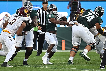 Sep 1, 2023; East Lansing, Michigan, USA;  Michigan State Spartans running back Nathan Carter (5) runs through a hole in the Central Michigan Chippewas line in the second quarter at Spartan Stadium. Mandatory Credit: Dale Young-USA TODAY Sports