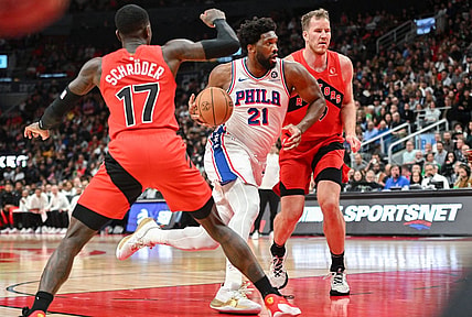Oct 28, 2023; Toronto, Ontario, CAN;  Philadelphia 76ers center Joel Embiid (21) drives to the basket between Toronto Raptors center Jakob Poeltl (19) and guard Dennis Schroder (17) in the first half at Scotiabank Arena. Mandatory Credit: Dan Hamilton-USA TODAY Sports