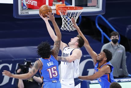Mar 29, 2021; Oklahoma City, Oklahoma, USA; Dallas Mavericks guard Luka Doncic (77) goes to the basket between Oklahoma City Thunder forward Josh Hall (15) and forward Tony Bradley (13) during the first quarter at Chesapeake Energy Arena. Mandatory Credit: Alonzo Adams-USA TODAY Sports
