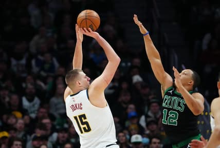 Jan 1, 2023; Denver, Colorado, USA; Denver Nuggets center Nikola Jokic (15) line up a shot over Boston Celtics forward Grant Williams (12) in the fourth quarter at Ball Arena. Mandatory Credit: Ron Chenoy-USA TODAY Sports