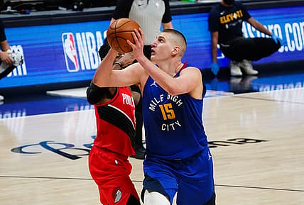 May 22, 2021; Denver, Colorado, USA; Denver Nuggets center Nikola Jokic (15) shoots the ball past Portland Trail Blazers guard CJ McCollum (3) in the second quarter during game one in the first round of the 2021 NBA Playoffs. at Ball Arena. Mandatory Credit: Ron Chenoy-USA TODAY Sports