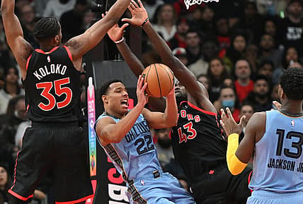 Dec 29, 2022; Toronto, Ontario, CAN;   Memphis Grizzlies forward Desmond Bane (22) tries to make a pass under the arms of Toronto Raptors center Christian Koloko (35) and forward Pascal Siakam (43) in the first half at Scotiabank Arena. Mandatory Credit: Dan Hamilton-USA TODAY Sports