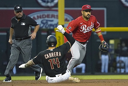 Apr 10, 2021; Phoenix, Arizona, USA; Arizona Diamondbacks third baseman Asdrubal Cabrera (14) slides into second base safely against Cincinnati Reds third baseman Eugenio Suarez (7) during a game at Chase Field. Mandatory Credit: Rick Scuteri-USA TODAY Sports
