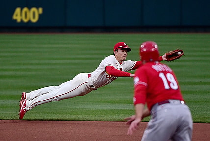 Apr 24, 2021; St. Louis, Missouri, USA;  St. Louis Cardinals second baseman Tommy Edman (19) dives and fields a ground ball as Cincinnati Reds first baseman Joey Votto (19) looks on during the fourth inning at Busch Stadium. Mandatory Credit: Jeff Curry-USA TODAY Sports