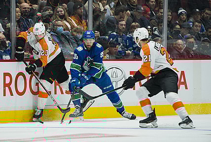 Oct 28, 2021; Vancouver, British Columbia, CAN; Philadelphia Flyers forward Oskar Lindblom (23) checks Vancouver Canucks forward Justin Bailey (95) in the first period at Rogers Arena. Mandatory Credit: Bob Frid-USA TODAY Sports