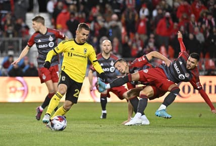 Mar 11, 2023; Toronto, Ontario, CAN;  Columbus Crew midfielder Alexandru Matan (20) controls the ball as Toronto FC defender Raoul Petretta (28) collides with a teammate in the first half at BMO Field. Mandatory Credit: Dan Hamilton-USA TODAY Sports