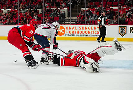 Nov 26, 2023; Raleigh, North Carolina, USA;  Carolina Hurricanes goaltender Pyotr Kochetkov (52) and right wing Andrei Svechnikov (37) stop the scoring attempt by Columbus Blue Jackets right wing Justin Danforth (17) during the second period at PNC Arena. Mandatory Credit: James Guillory-USA TODAY Sports