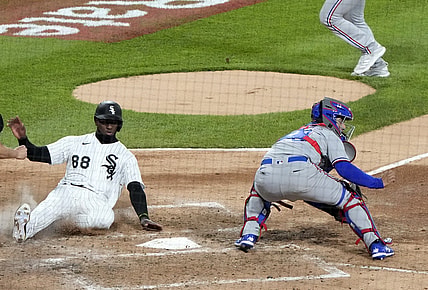 Apr 23, 2021; Chicago, Illinois, USA; Chicago White Sox center fielder Luis Robert (88) slides home safely to score a run against the Texas Rangers during the third inning at Guaranteed Rate Field. Mandatory Credit: Mike Dinovo-USA TODAY Sports