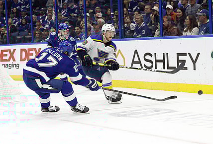 Dec 2, 2021; Tampa, Florida, USA; St. Louis Blues defenseman Scott Perunovich (48) passes the puck as Tampa Bay Lightning left wing Alex Killorn (17) defends during the first period at Amalie Arena. Mandatory Credit: Kim Klement-USA TODAY Sports