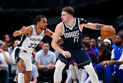 Dec 23, 2023; Dallas, Texas, USA; Dallas Mavericks guard Luka Doncic (77) controls the ball as San Antonio Spurs guard Tre Jones (33) defends during the second quarter at American Airlines Center. Mandatory Credit: Kevin Jairaj-USA TODAY Sports