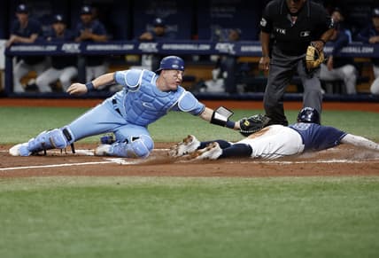 May 13, 2022; St. Petersburg, Florida, USA; Tampa Bay Rays second baseman Brandon Lowe (8) slides into home plate safe as Toronto Blue Jays catcher Tyler Heineman (22) attempted to tag him out during the second inning at Tropicana Field. Mandatory Credit: Kim Klement-USA TODAY Sports