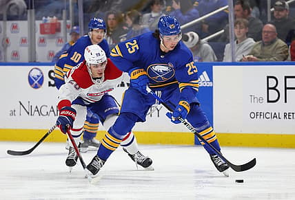 Oct 23, 2023; Buffalo, New York, USA;  Buffalo Sabres defenseman Owen Power (25) looks to control the puck as Montreal Canadiens left wing Juraj Slafkovsky (20) defends during the third period at KeyBank Center. Mandatory Credit: Timothy T. Ludwig-USA TODAY Sports