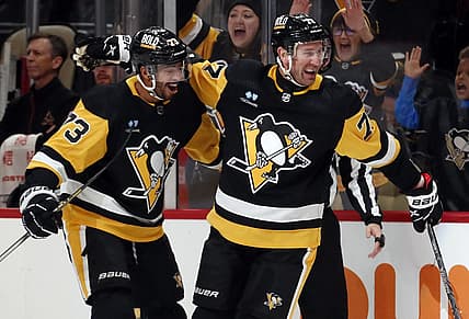 Dec 12, 2023; Pittsburgh, Pennsylvania, USA; Pittsburgh Penguins center Jeff Carter (77) reacts with defenseman Pierre-Olivier Joseph (73) after Carter scored a short-handed goal against the Arizona Coyotes during the first period at PPG Paints Arena. Pittsburgh won 4-2. Mandatory Credit: Charles LeClaire-USA TODAY Sports