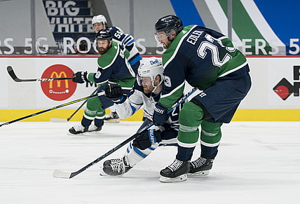 Feb 19, 2021; Vancouver, British Columbia, CAN; Vancouver Canucks defenseman Alexander Edler (23) checks Winnipeg Jets forward Nikolaj Ehlers (27) in the second period at Rogers Arena. Mandatory Credit: Bob Frid-USA TODAY Sports