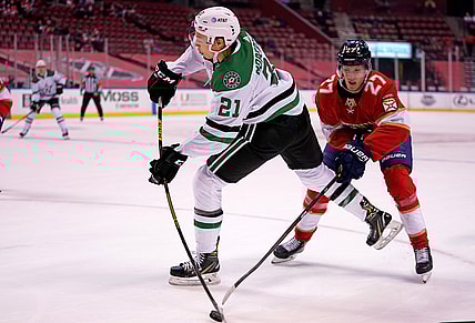 Feb 25, 2021; Sunrise, Florida, USA; Dallas Stars left wing Jason Robertson (21) shoots the puck in front of Florida Panthers center Eetu Luostarinen (27) during the first period at BB&T Center. Mandatory Credit: Jasen Vinlove-USA TODAY Sports