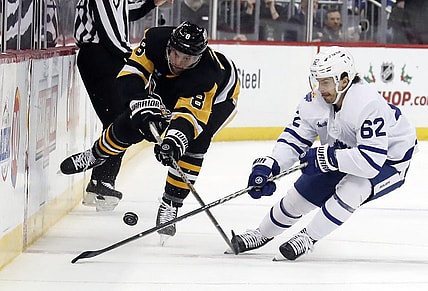 Nov 26, 2022; Pittsburgh, Pennsylvania, USA;  Pittsburgh Penguins defenseman Brian Dumoulin (8) and Toronto Maple Leafs center Denis Malgin (62) battle for the puck during the second period at PPG Paints Arena. Toronto won 4-1. Mandatory Credit: Charles LeClaire-USA TODAY Sports
