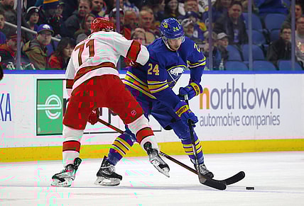 Apr 8, 2023; Buffalo, New York, USA;  Carolina Hurricanes right wing Jesper Fast (71) and Buffalo Sabres center Dylan Cozens (24) go after a loose puck during the first period at KeyBank Center. Mandatory Credit: Timothy T. Ludwig-USA TODAY Sports