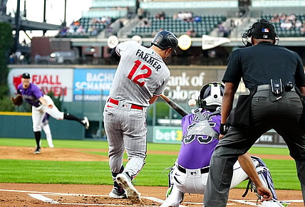 Sep 29, 2023; Denver, Colorado, USA; Minnesota Twins short stop Kyle Farmer (12) RBI singles in the first inning against the Colorado Rockies at Coors Field. Mandatory Credit: Ron Chenoy-USA TODAY Sports