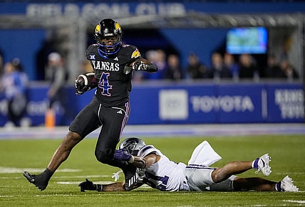Nov 18, 2023; Lawrence, Kansas, USA; Kansas Jayhawks running back Devin Neal (4) runs the ball against Kansas State Wildcats safety Marques Sigle (21) during the first half at David Booth Kansas Memorial Stadium. Mandatory Credit: Jay Biggerstaff-USA TODAY Sports