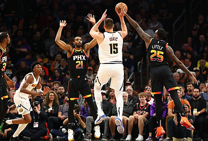 Dec 1, 2023; Phoenix, Arizona, USA; Denver Nuggets center Nikola Jokic (15) passes the ball against Phoenix Suns forward Keita Bates-Diop (21) and forward Nassir Little (25) in the first half at Footprint Center. Mandatory Credit: Mark J. Rebilas-USA TODAY Sports