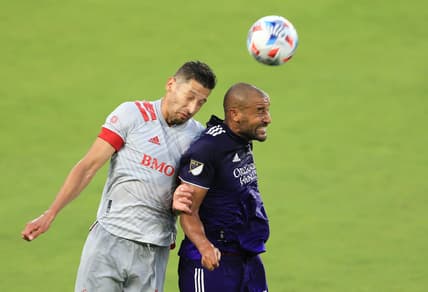 May 22, 2021; Orlando, Florida, USA; Toronto FC defender Omar Gonzalez (44) and Orlando City forward Tesho Akindele (13) jump to head the ball at Orlando City Stadium. Mandatory Credit: Matt Stamey-USA TODAY Sports