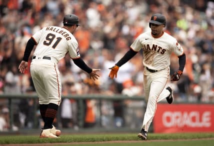 Aug 3, 2023; San Francisco, California, USA; San Francisco Giants first baseman LaMonte Wade Jr. (right) gets a congratulatory handshake from third base coach Mark Hallberg (91) after hitting a solo home run off Arizona Diamondbacks starting pitcher Brandon Pfaadt during the fourth inning at Oracle Park. Mandatory Credit: D. Ross Cameron-USA TODAY Sports