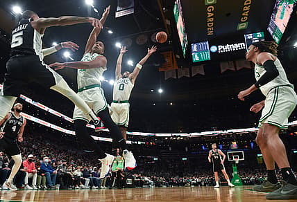 Jan 5, 2022; Boston, Massachusetts, USA;  San Antonio Spurs guard Dejounte Murray (5) passes the ball past Boston Celtics center Al Horford (42) and forward Jayson Tatum (0) during the first half at TD Garden. Mandatory Credit: Bob DeChiara-USA TODAY Sports