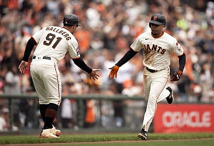 Aug 3, 2023; San Francisco, California, USA; San Francisco Giants first baseman LaMonte Wade Jr. (right) gets a congratulatory handshake from third base coach Mark Hallberg (91) after hitting a solo home run off Arizona Diamondbacks starting pitcher Brandon Pfaadt during the fourth inning at Oracle Park. Mandatory Credit: D. Ross Cameron-USA TODAY Sports