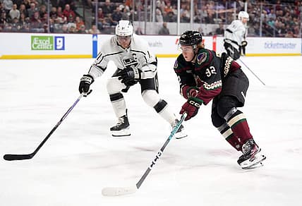 Oct 27, 2023; Tempe, Arizona, USA; Arizona Coyotes center Logan Cooley (92) skates against Los Angeles Kings center Anze Kopitar (11) during the first period at Mullett Arena. Mandatory Credit: Joe Camporeale-USA TODAY Sports