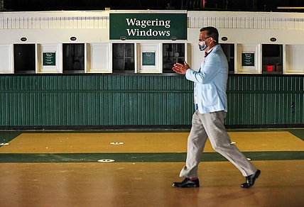 Sep 4, 2020; Louisville, Kentucky, USA;  A man rubs his hands with sanitizer as he walks past empty Wagering Windows at Churchill Downs on the 2020 Oaks Day Friday morning. No fans are allowed for Oaks nor the Kentucky Derby due to Covid-19: only horse owners, trainers, jockeys and family. Mandatory Credit: Matt Stone/Louisville Courier-Journal-USA TODAY NETWORK