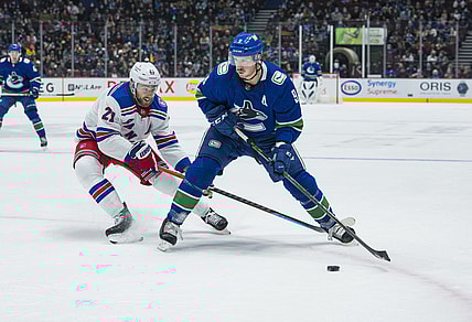 Nov 2, 2021; Vancouver, British Columbia, CAN; New York Rangers  forward Barclay Goodrow (21) checks Vancouver Canucks forward J.T. Miller (9) in the first period at Rogers Arena. Mandatory Credit: Bob Frid-USA TODAY Sports