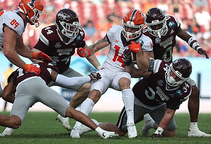 Jan 2, 2023; Tampa, FL, USA; Illinois Fighting Illini wide receiver Casey Washington (14) runs with the ball as Mississippi State Bulldogs linebacker Jett Johnson (44) and linebacker Sherman Timbs (34) defends during the first half in the 2023 ReliaQuest Bowl at Raymond James Stadium. Mandatory Credit: Kim Klement-USA TODAY Sports