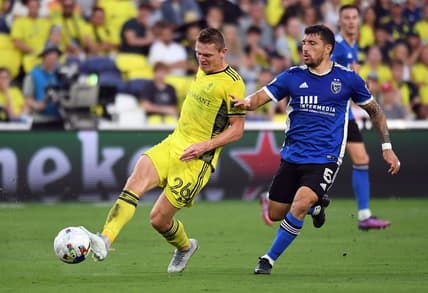 Jun 11, 2022; Nashville, Tennessee, USA; Nashville SC midfielder Luke Haakenson (26) passes the ball against San Jose Earthquakes midfielder Eric Remedi (5) during the first half at Geodis Park. Mandatory Credit: Christopher Hanewinckel-USA TODAY Sports