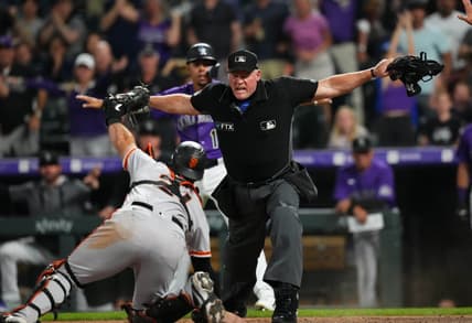 Sep 20, 2022; Denver, Colorado, USA; MLB home plate umpire Ted Barrett (65) signals safe towards San Francisco Giants catcher Joey Bart (21) in the eighth inning against the Colorado Rockies at Coors Field. Mandatory Credit: Ron Chenoy-USA TODAY Sports