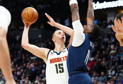 Feb 7, 2023; Denver, Colorado, USA; Denver Nuggets center Nikola Jokic (15) shoots the ball at Minnesota Timberwolves center Naz Reid (11) in the first quarter at Ball Arena. Mandatory Credit: Ron Chenoy-USA TODAY Sports