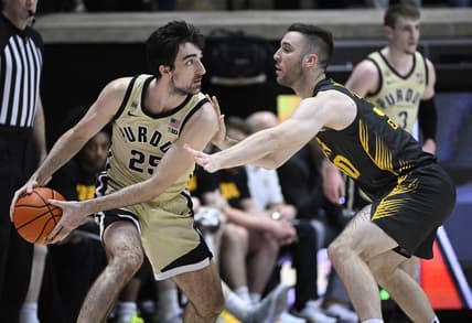 Feb 9, 2023; West Lafayette, Indiana, USA; Purdue Boilermakers guard Ethan Morton (25) keeps the ball away from Iowa Hawkeyes guard Connor McCaffery (30) during the first half at Mackey Arena. Mandatory Credit: Marc Lebryk-USA TODAY Sports