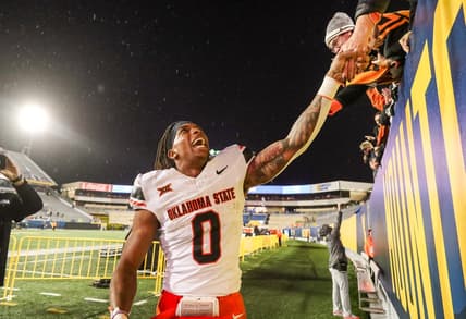 Oct 21, 2023; Morgantown, West Virginia, USA; Oklahoma State Cowboys running back Ollie Gordon II (0) celebrates with fans after defeating the West Virginia Mountaineers at Mountaineer Field at Milan Puskar Stadium. Mandatory Credit: Ben Queen-USA TODAY Sports