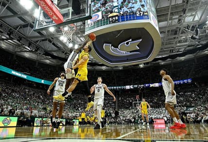 Jan 30, 2024; East Lansing, Michigan, USA; Michigan Wolverines forward Olivier Nkamhoua (13) gets blocked by Michigan State Spartans forward Coen Carr (55) during the first half at Jack Breslin Student Events Center. Mandatory Credit: Dale Young-USA TODAY Sports